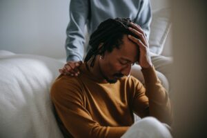 A sad man dealing with grief in support of another person. Unload It Therapy in Houston, Tx, is the place to go when experiencing grief and trauma. 